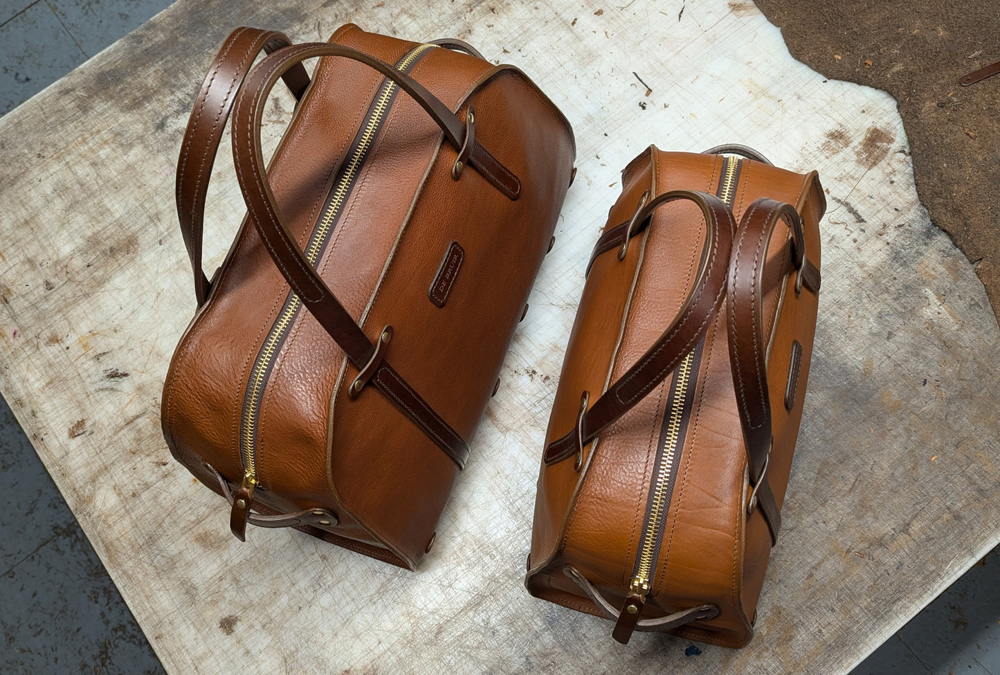 Top view of two leather bags of different sizes on wooden background