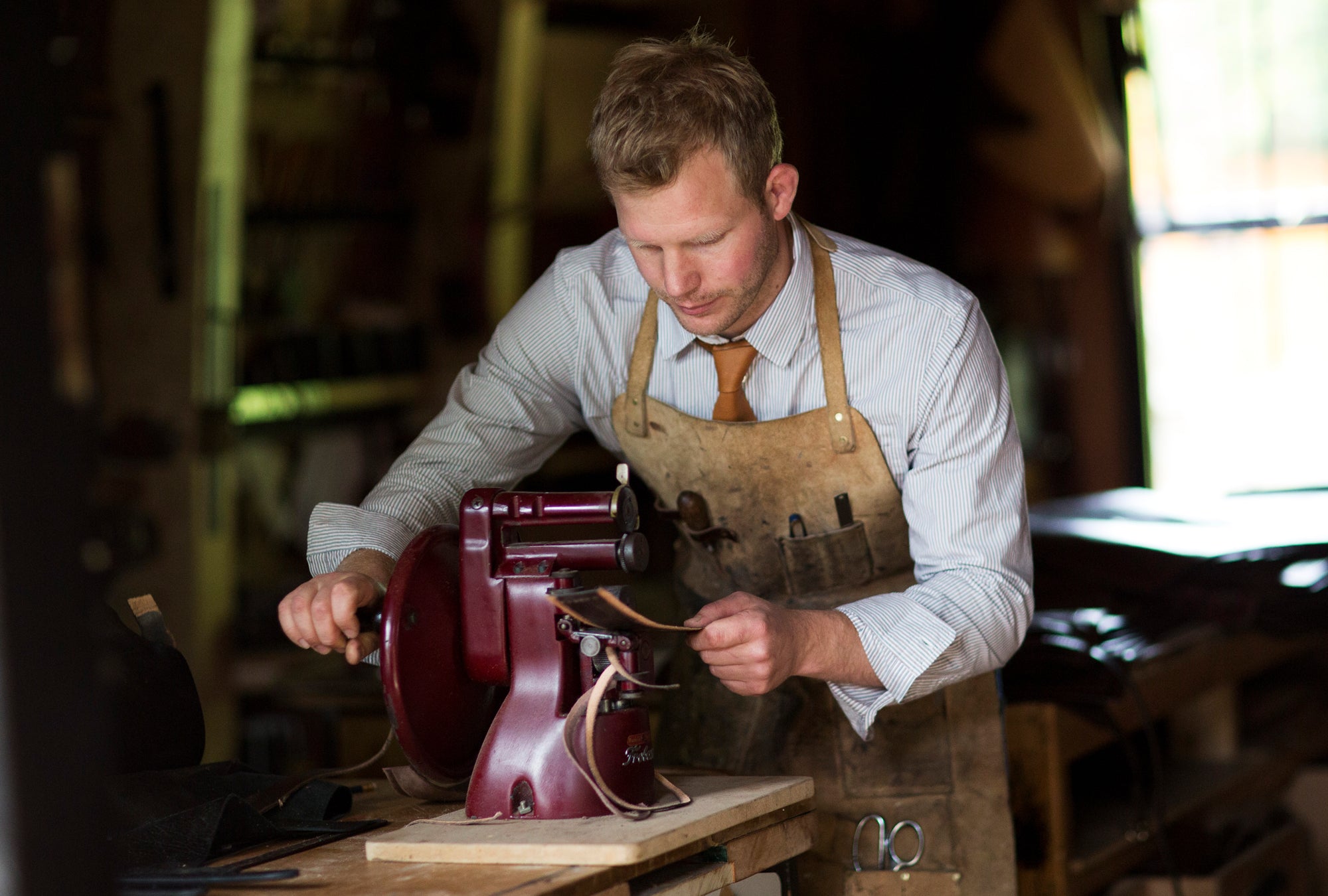 Garvan de Bruir working on a metal sowing machine in workshop