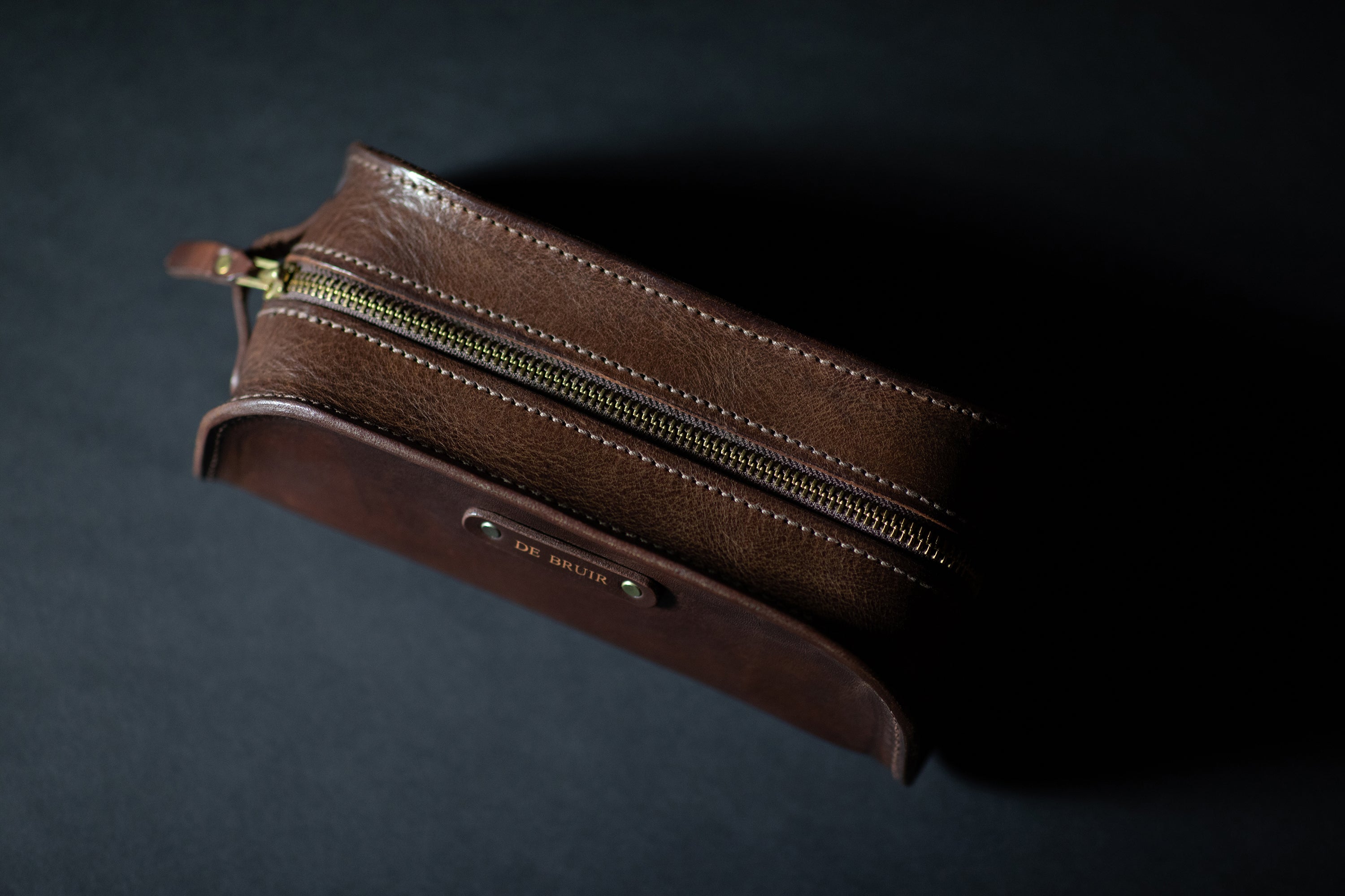 Top view of leather washbag showing closed gold zip