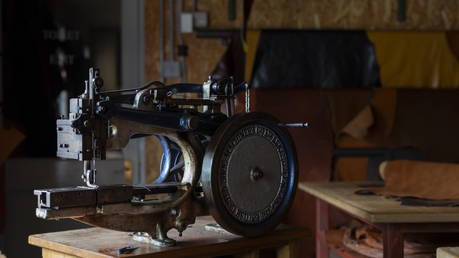 Close up of a metal sowing machine, blurred workshop background